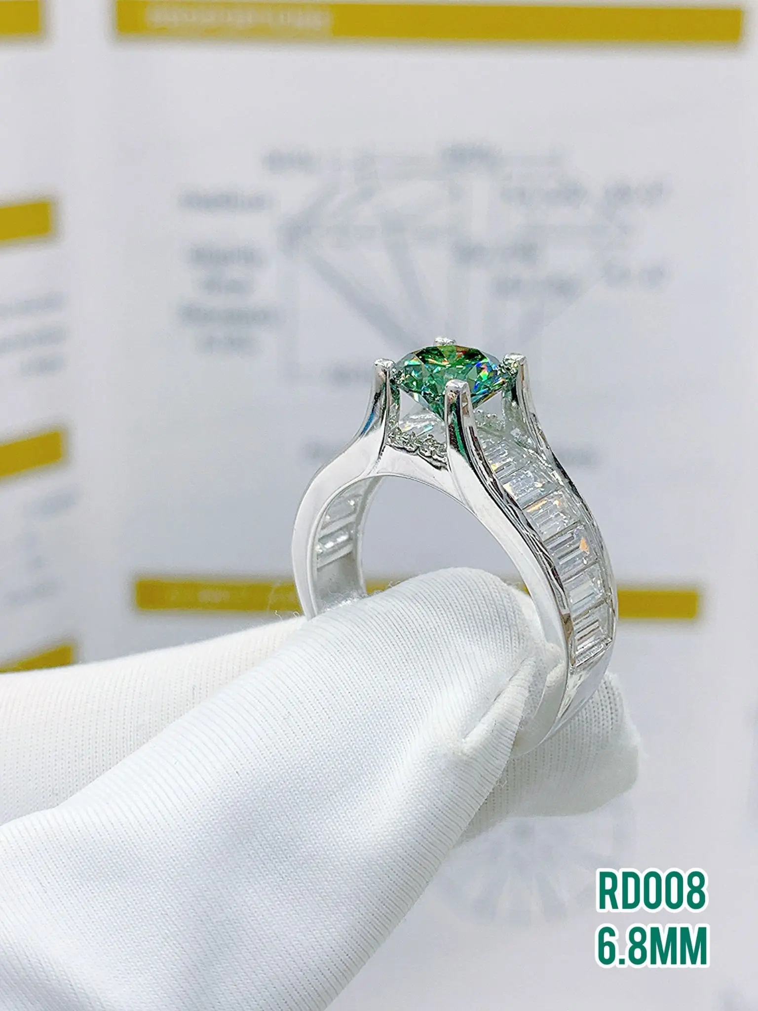 Nhẫn bạc nữ có viên moissanite chủ màu xanh 6.8mm, hai bên vai nhẫn xếp hàng đá baguette, mã RD008